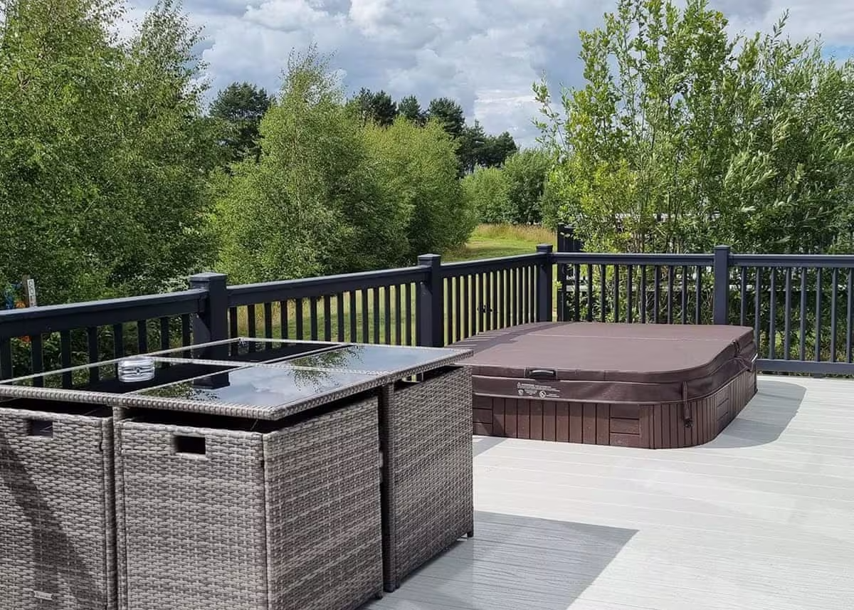 A private hot tub on lodge decking at Woodhall Country Park