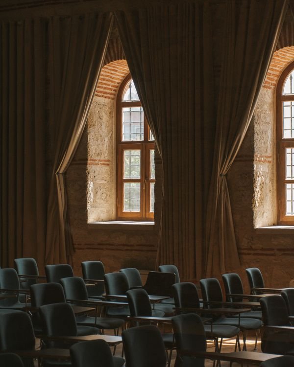 Rows of chairs beneath tall arched windows; representative hall photograph