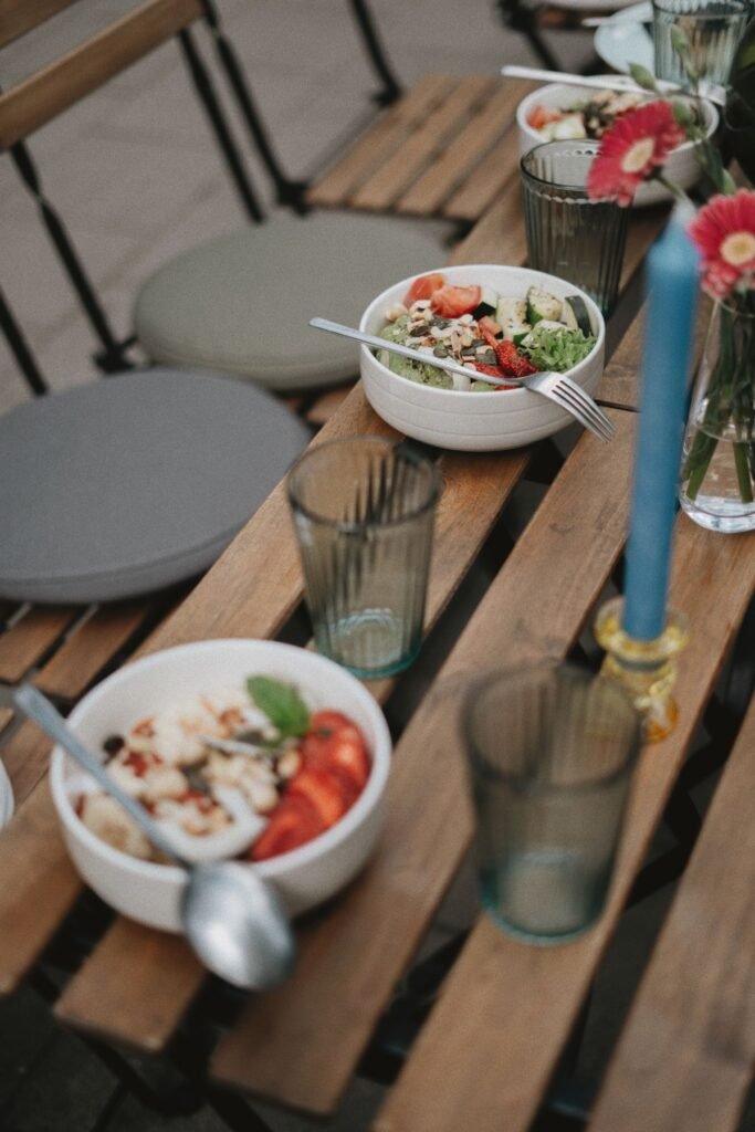 Bowls of food and glasses arranged on a dining table; representative luncheon photograph