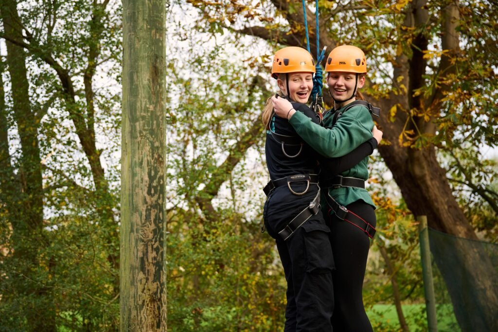 Two Scouts wearing helmets and safety harnesses during an outdoor activity; representative Scouts photograph