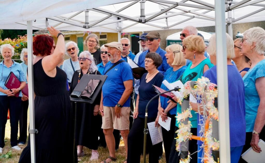 Sing It Loud Woodhall Spa choir performing under a gazebo at Martin Village Fete