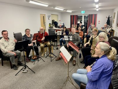 Woodhall Spa Community Band members rehearsing together with their instruments